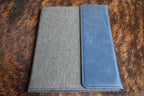 Indigo blue Premium Leatherette padfolio, shown closed on a cowhide surface