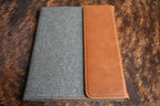 Heritage Rawhide Premium Leatherette padfolio, shown closed on a cowhide surface