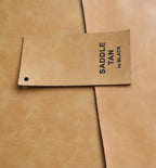 Saddle Tan Premium Leatherette material swatch, tan with a black engraving, the finish used for this can cooler