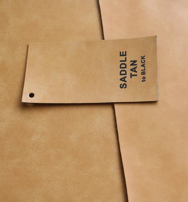 Saddle Tan Premium Leatherette material swatch, tan with a black engraving, the finish used for this can cooler