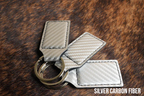 Three silver carbon fiber Premium Leatherette keychains with a woven texture, fanned out on a split ring.