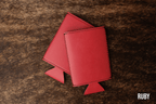 Ruby red Premium Leatherette slim can coolers, sized for slim cans, laid flat and collapsed.