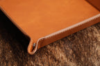 Close-up of the valet tray's stitched edge and corner snap fastener showing the thickness of the leatherette