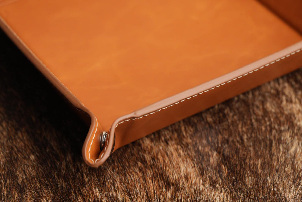Close-up of the valet tray's stitched edge and corner snap fastener showing the thickness of the leatherette