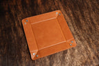 Tan leatherette valet tray with all four corner snaps fastened, viewed at an angle